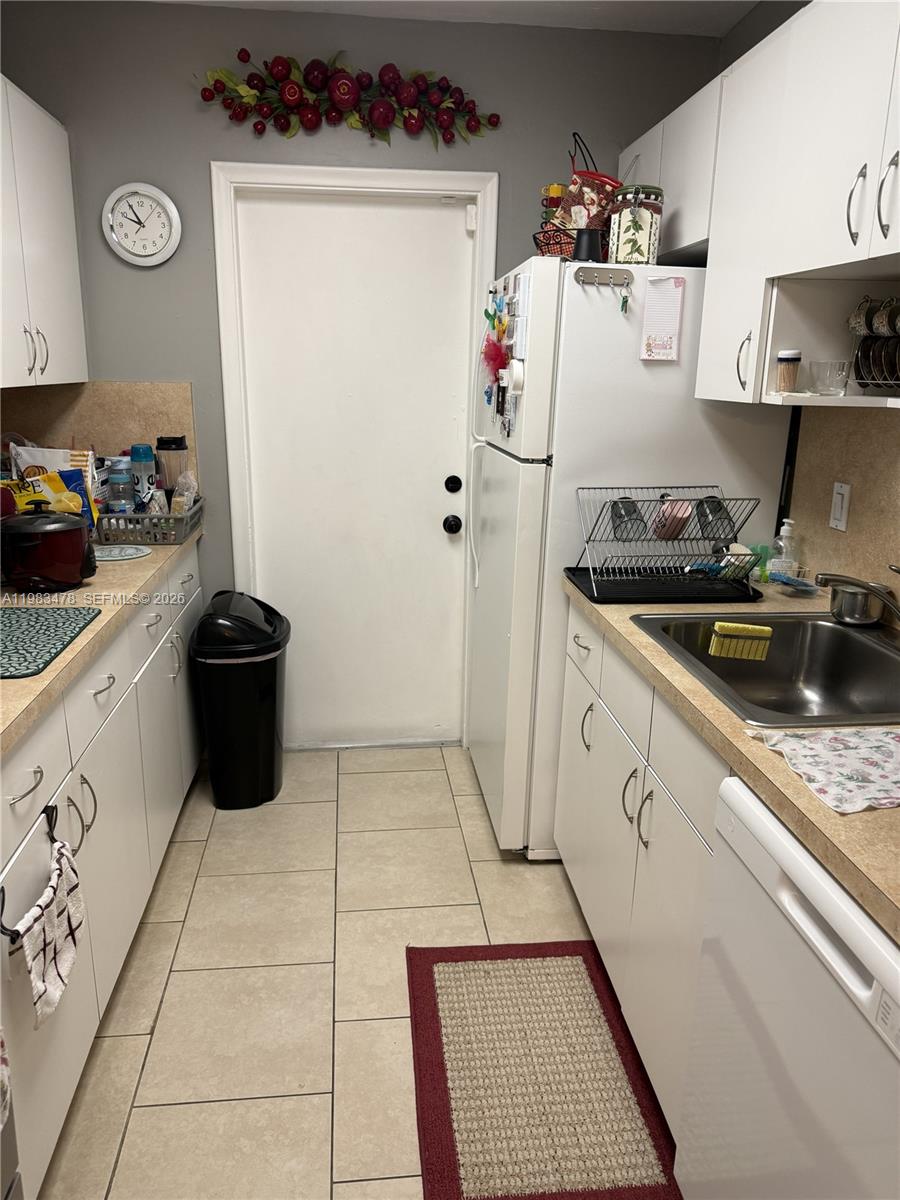 7845 Miller Drive, Unit A204 Miami, FL 33155 - Photo 4 of 6 a kitchen with a cabinets and white appliances