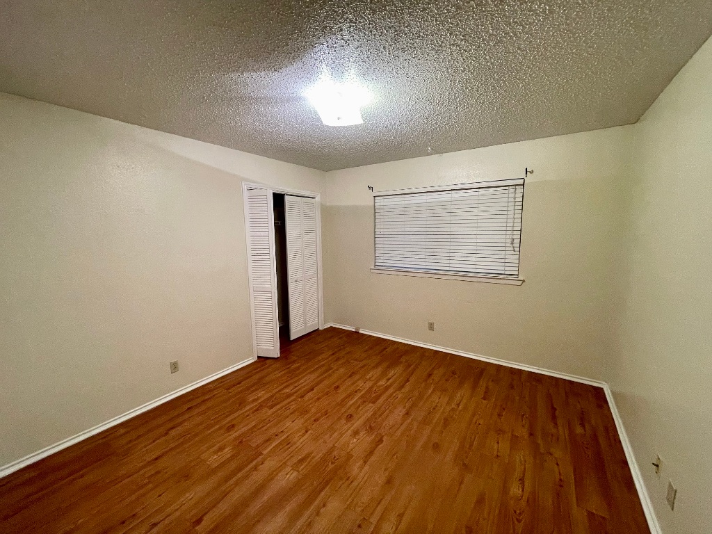 10003 Parliament House Road Austin, TX 78717 - Photo 11 of 31 an empty room with wooden floor cabinet and windows