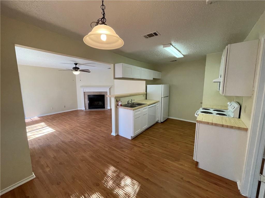 10003 Parliament House Road Austin, TX 78717 - Photo 31 of 31 a kitchen with granite countertop a stove and a wooden floors