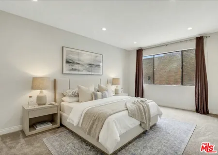 a bedroom with a large bed and a large window