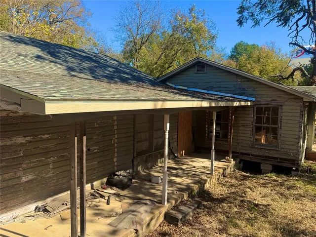 a view of house with wooden fence in front of it