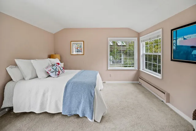 a bedroom with a bed a dresser and a window
