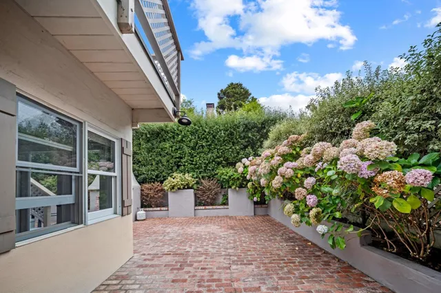 an aerial view of ocean and residential houses with outdoor space