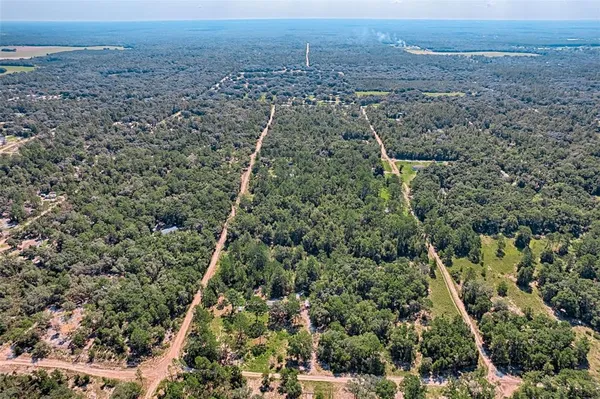an aerial view of house with yard and mountain in back
