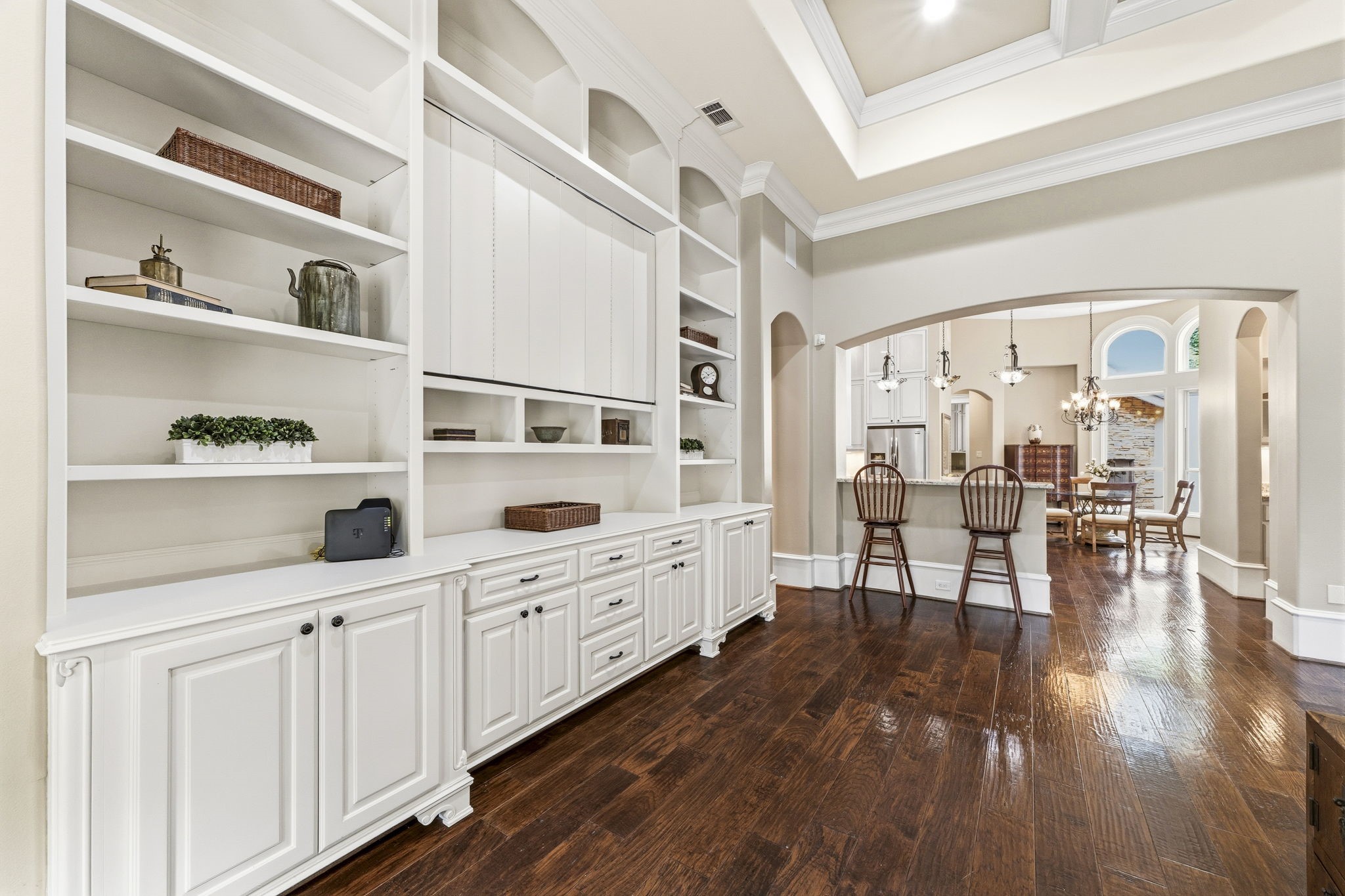 27402 Jacob's Path Lane Spring, TX 77386 - Photo 13 of 48 Custom built-in shelving and cabinetry anchor one end of the living space, showcasing the exceptional craftsmanship and detailed woodwork found throughout the home. Masterfully crafted cabinet doors conceal the television when not in use, creating an elegant and refined focal point.