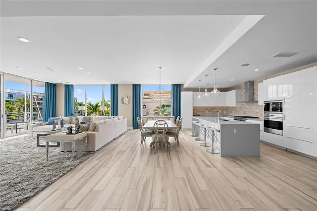 a view of a dining room and livingroom with furniture wooden floor a chandelier