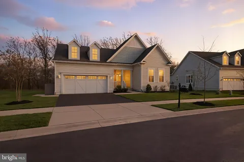 a view of a house with a big yard and large trees