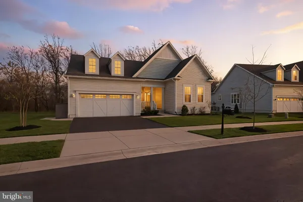 a view of a house with a big yard and large trees