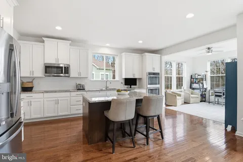 a large kitchen with kitchen island granite countertop a table and chairs