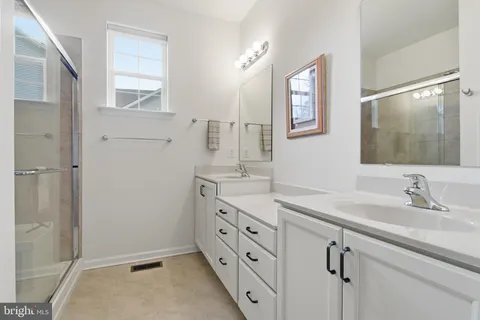 a spacious bathroom with a double vanity sink and a mirror