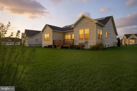 a front view of a house with a garden and a tree