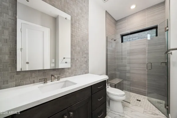a bathroom with a sink a toilet a shower and a mirror