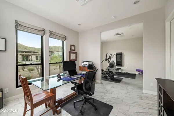 a view of a workspace with furniture and a window