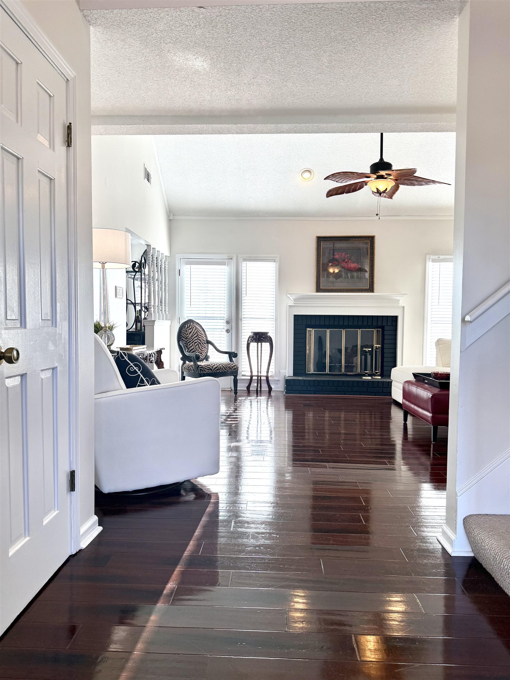825 North Walnut Bend Road Memphis, TN 38018 - Photo 8 of 40 a living room with couches a fireplace and a dining table with wooden floor