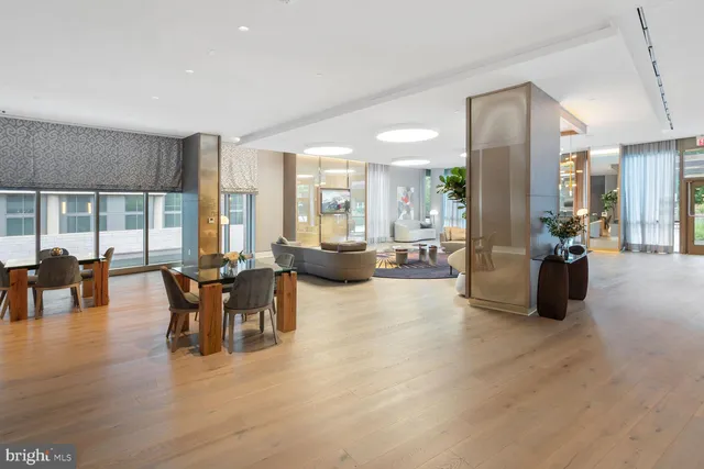 a living room with furniture a wooden floor and a large window