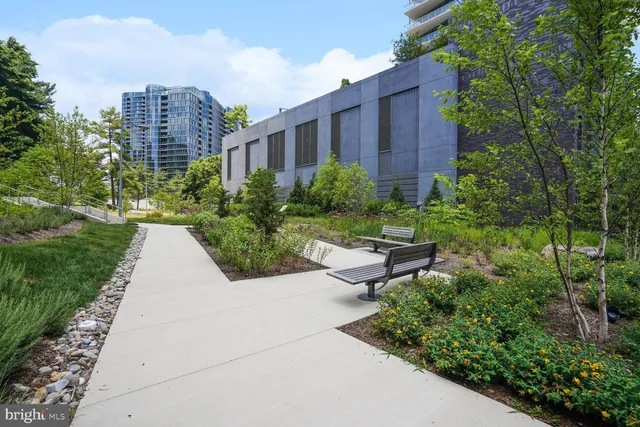 a view of a garden with a bench in front of house