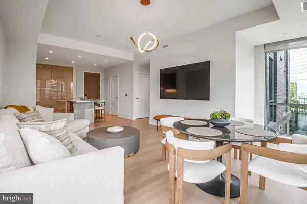 a dining room with wooden floor and large windows