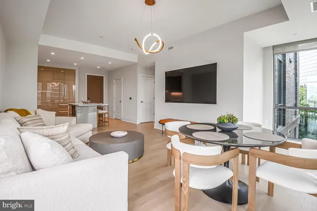 a dining room with wooden floor and large windows