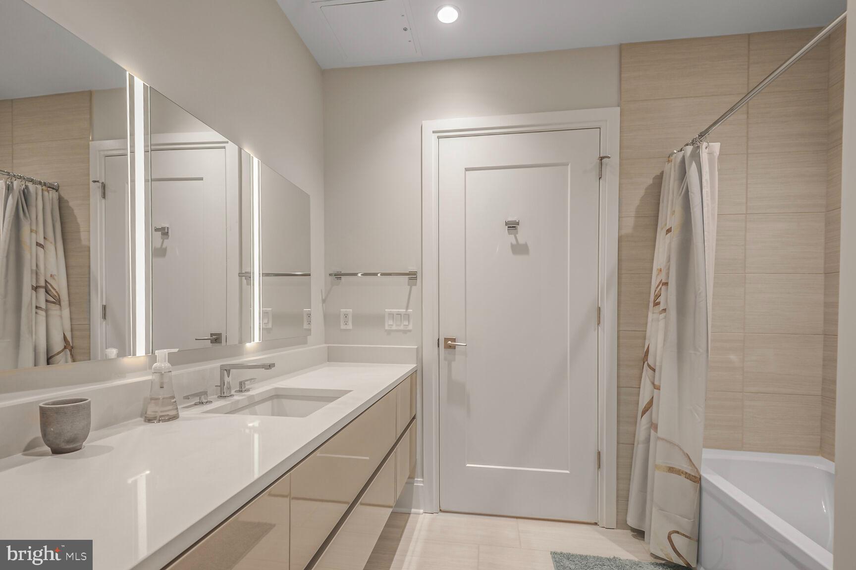 7887 Jones Branch Drive, Unit 803 McLean, VA 22102 - Photo 8 of 35 a bathroom with a shower sink vanity and mirror