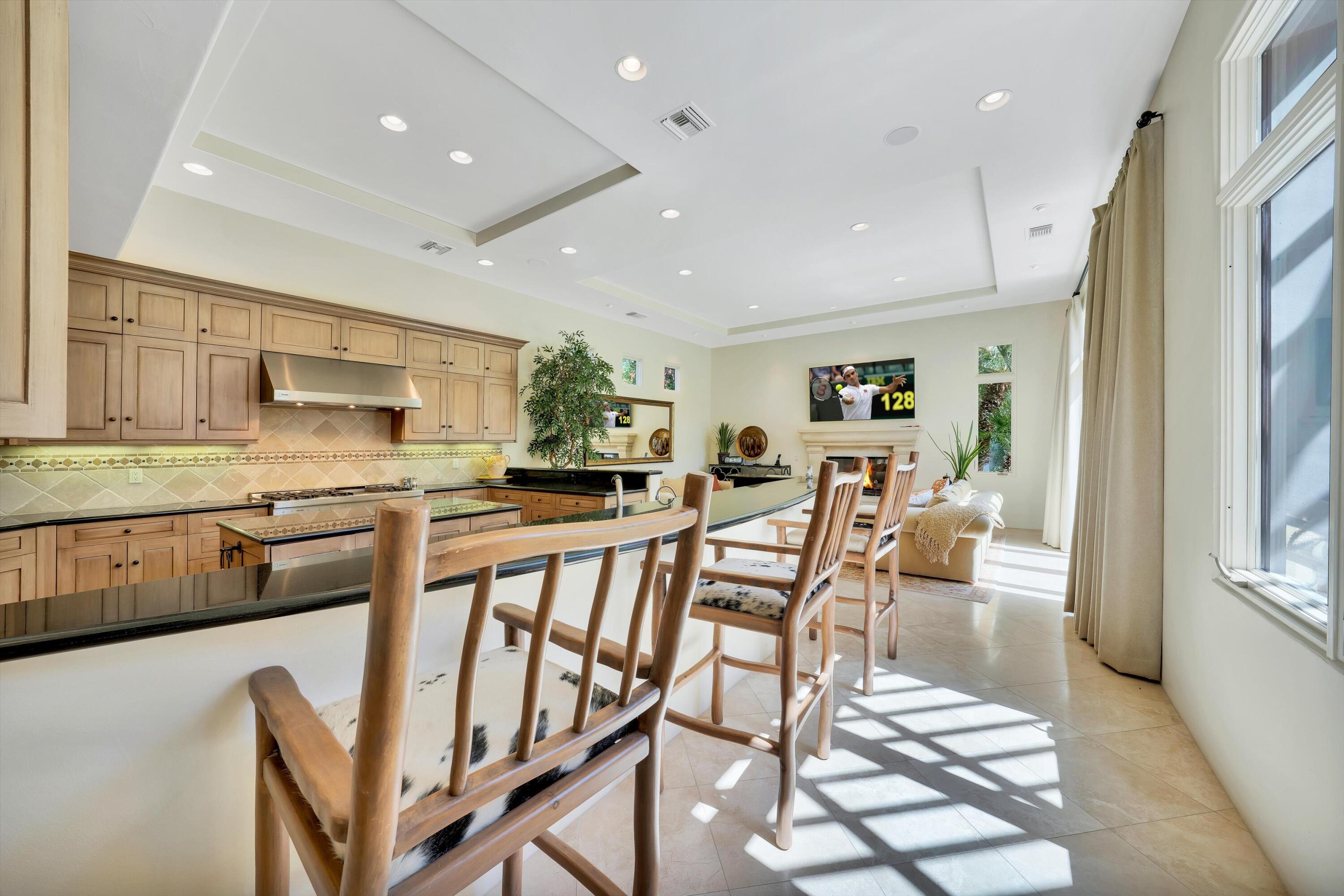 78411 Talking Rock Turn La Quinta, CA 92253 - Photo 42 of 70 a dining area with stainless steel appliances kitchen island granite countertop a dining table chairs and granite counter tops