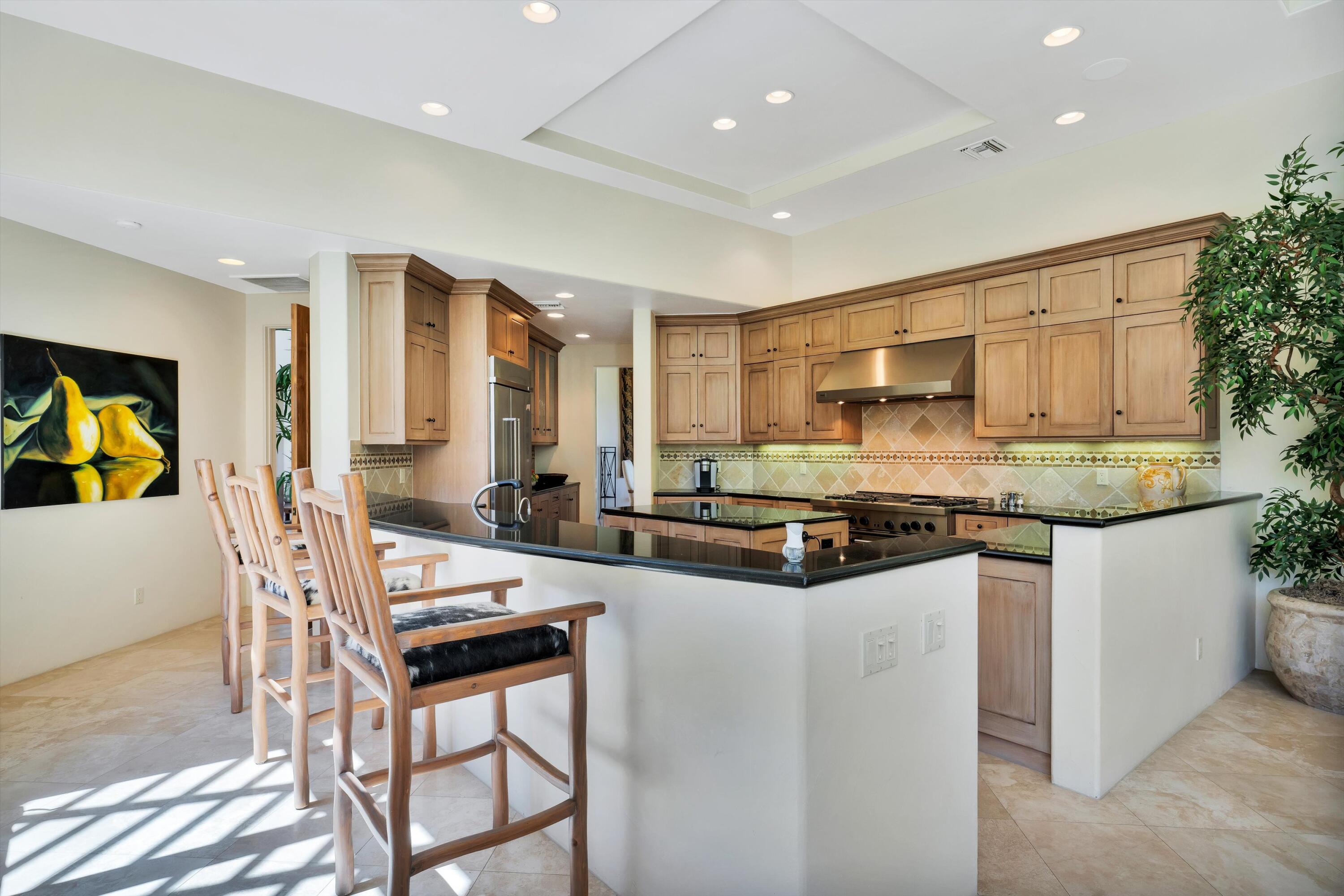 78411 Talking Rock Turn La Quinta, CA 92253 - Photo 43 of 70 a kitchen with stainless steel appliances granite countertop a stove top oven a sink dishwasher and a refrigerator
