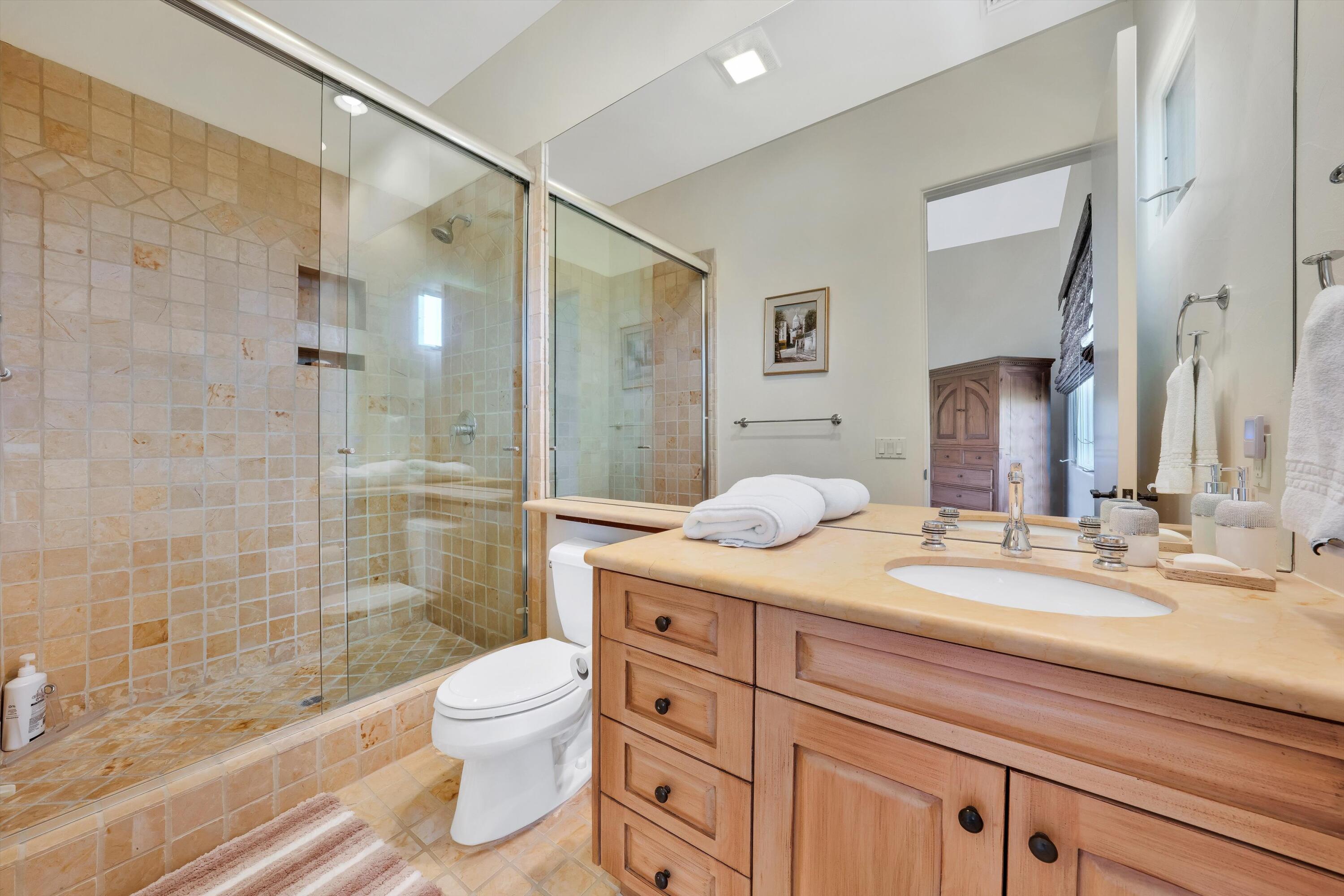 78411 Talking Rock Turn La Quinta, CA 92253 - Photo 61 of 70 a bathroom with a granite countertop sink toilet a large mirror a shower and vanity