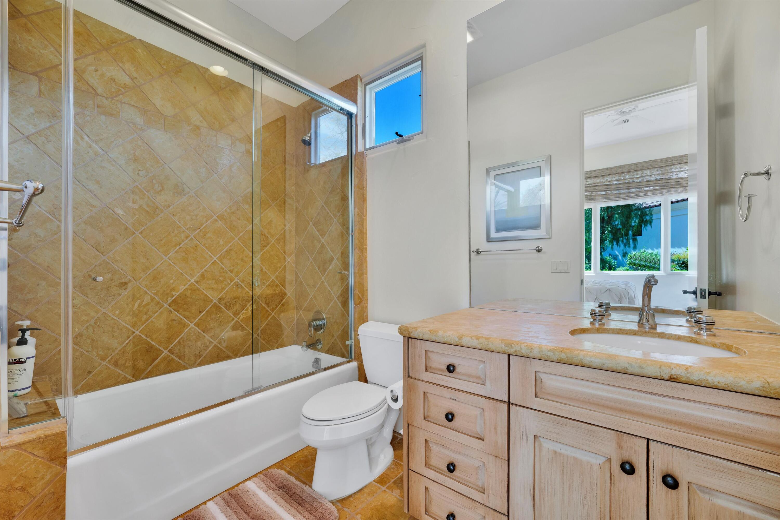 78411 Talking Rock Turn La Quinta, CA 92253 - Photo 63 of 70 a bathroom with a granite countertop sink a toilet and shower