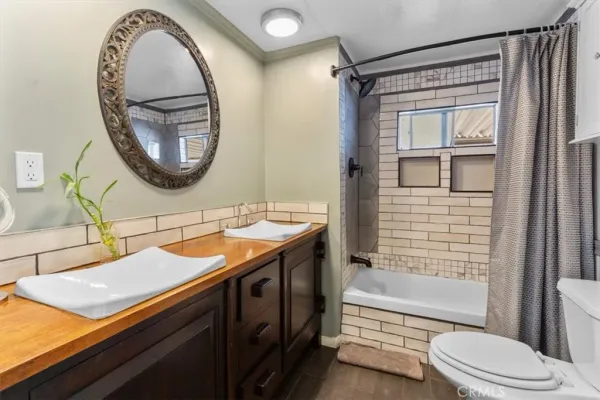 a bathroom with a granite countertop sink mirror toilet and bathtub