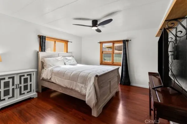 a bedroom with a bed wooden floor and window