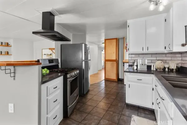 a kitchen with stainless steel appliances granite countertop a refrigerator a stove top oven a sink and dishwasher