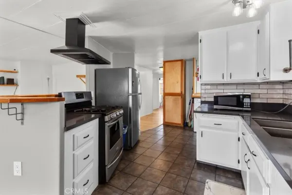 a kitchen with stainless steel appliances granite countertop a refrigerator a stove and a sink