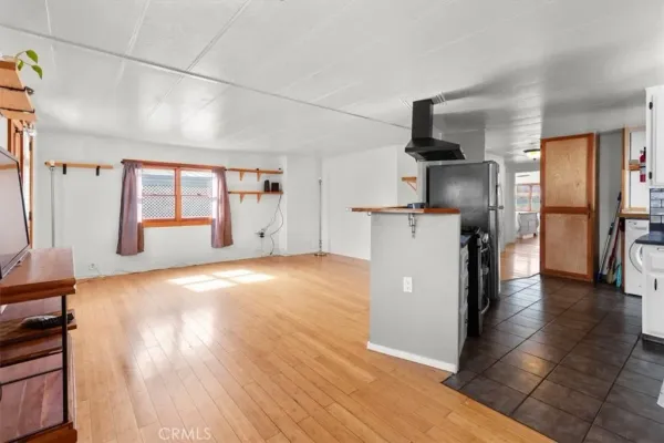 a kitchen with stainless steel appliances a refrigerator and wooden floor