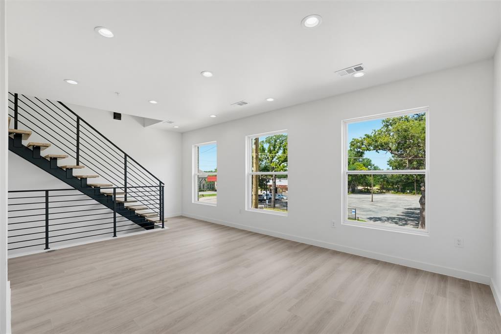 516 South O Connor Road Irving, TX 75060 - Photo 3 of 23 Open-concept living area featuring light wood-finish flooring, recessed lighting, and a modern staircase with black metal railings