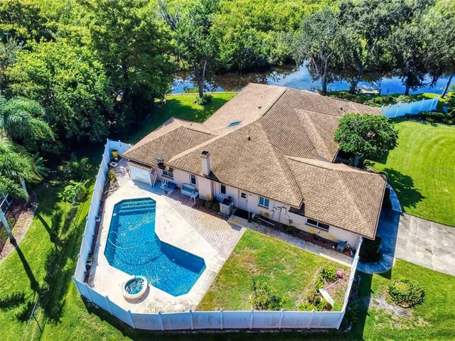 an aerial view of a house with a yard swimming pool and outdoor seating
