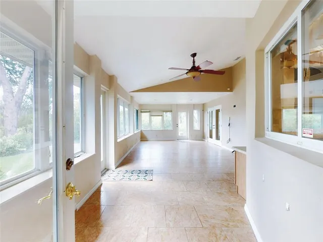 an empty room with a ceiling fan and a window