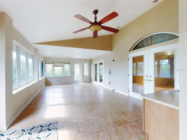 an empty room with a window and a fan