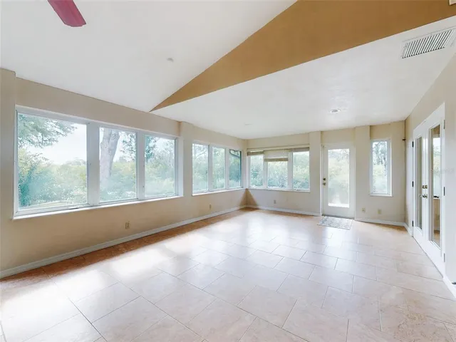an empty room with a ceiling fan and a window