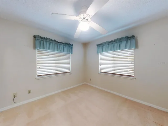 a view of a lake with a yard and a large tree