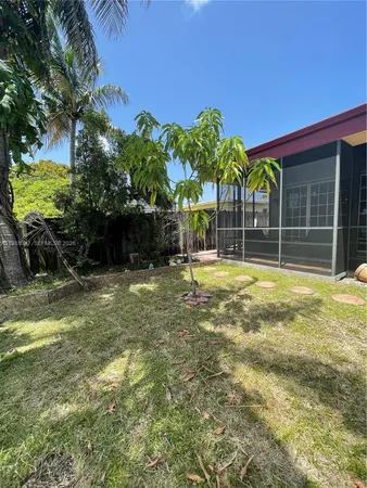 a living room with a bed and a dresser next to a window
