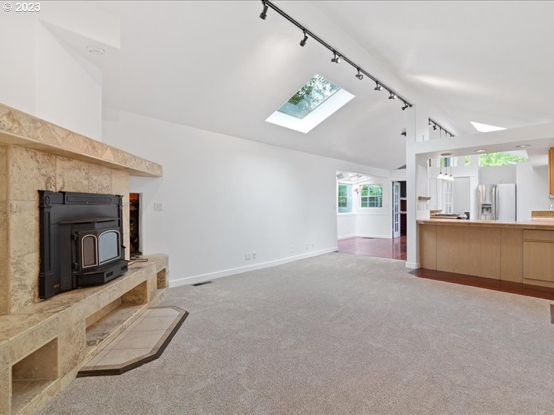 4155 Mapleton Drive West Linn, OR 97068 - Photo 7 of 38 a view of an empty room with a fireplace and a chandelier fan