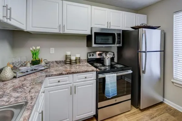 a kitchen with stainless steel appliances granite countertop a refrigerator sink and stove