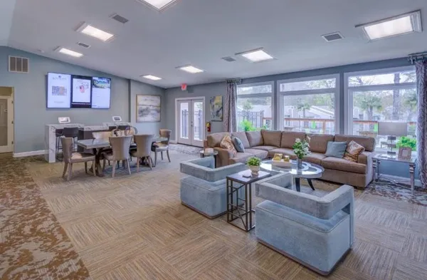 a living room with furniture and large windows