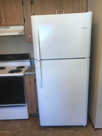 a white refrigerator freezer sitting in a kitchen