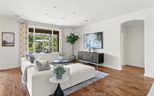 a living room with furniture a flat screen tv and wooden floor
