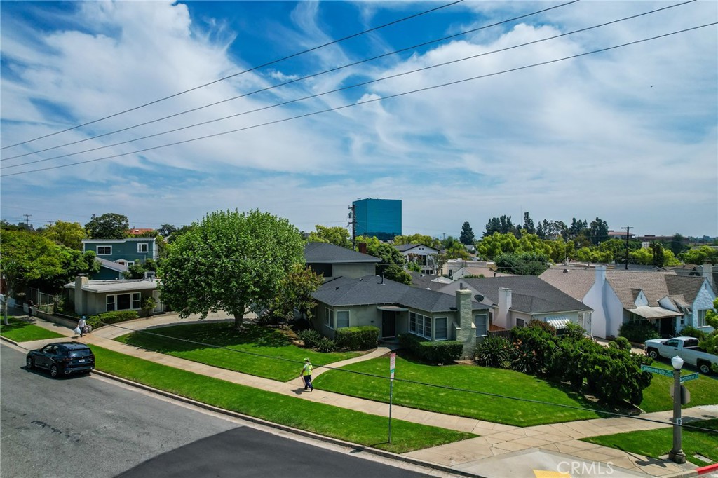 a front view of a house with a yard and potted plants