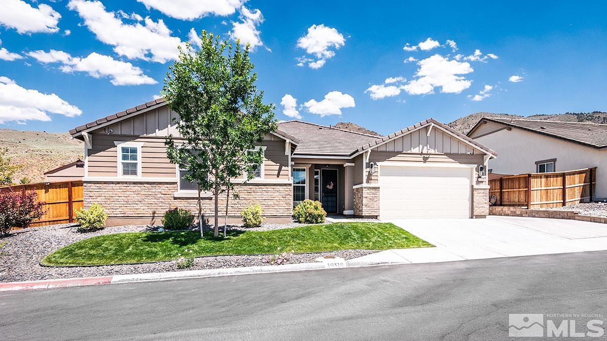 a front view of a house with a yard and a garage