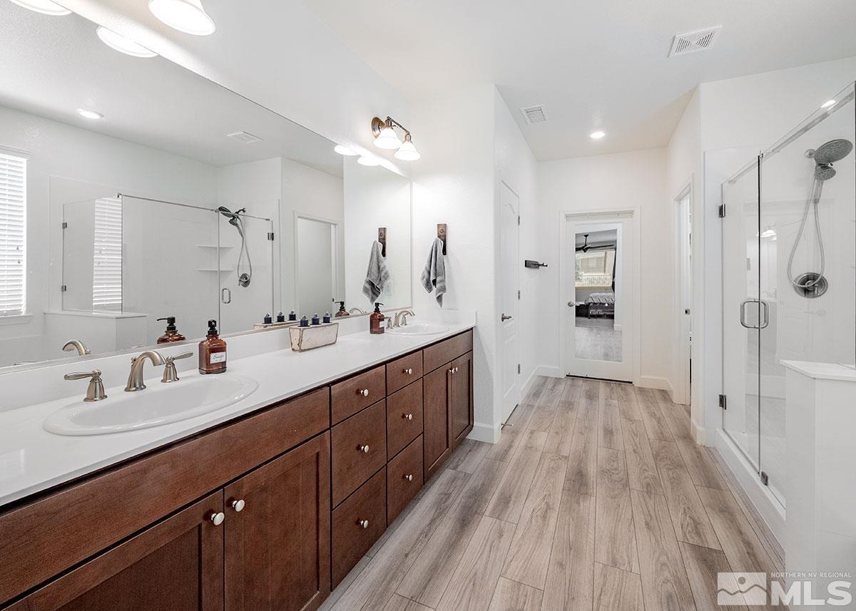 10310 Palladium Mine Drive Reno, NV 89521 - Photo 15 of 35 a spacious bathroom with a double vanity sink a large mirror a shower and a bathtub