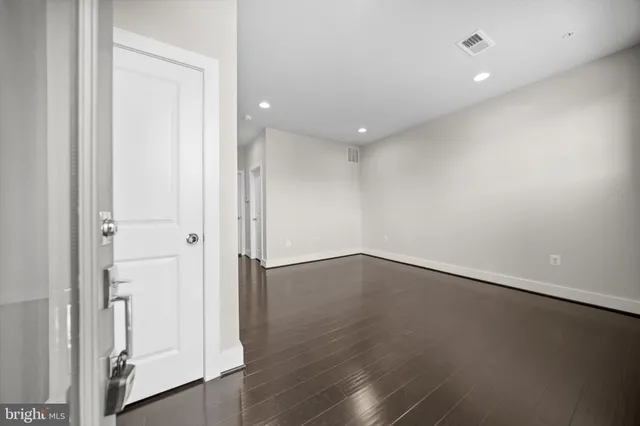 an empty room with wooden floor and entrance