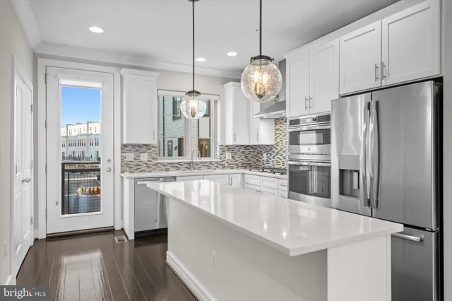 a large kitchen with granite countertop a large counter space stainless steel appliances and cabinets