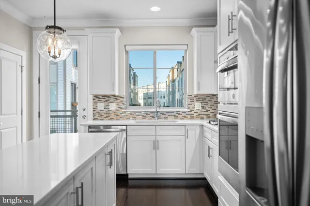 a kitchen with stainless steel appliances granite countertop a sink and refrigerator